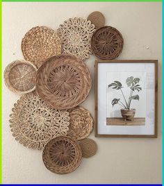 there are many wicker baskets on the wall with a potted plant next to it