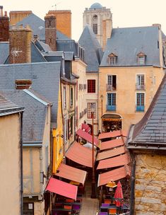 an overhead view of some buildings with red umbrellas on the tables in front of them