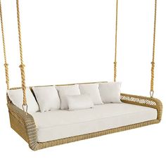 a wicker swing bed with white pillows on the front and back sides, hanging from a rope