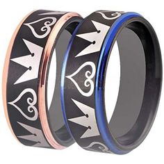 two black and blue wedding rings with crowns on each side, one has an arrow in the middle