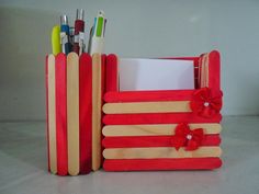 a pencil holder made out of popsicle sticks with flowers on the front and bottom