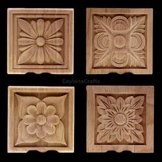 four carved wooden plaques with flowers and leaves in the center, each on a black background