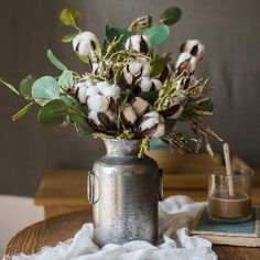 a vase filled with cotton sitting on top of a wooden table