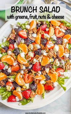 mixed greens salad with fruit on a white plate