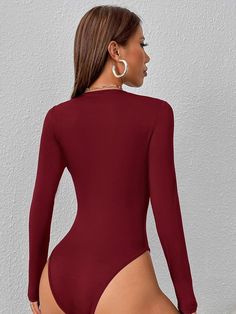 a woman in a maroon bodysuit