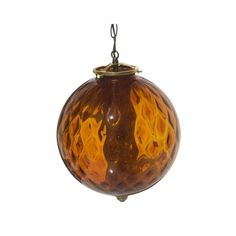 a brown and yellow glass ball hanging from a hook on a white background with clippings