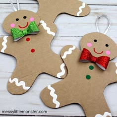 three christmas ornaments made out of cardboard with bows and gingerbreads on the top