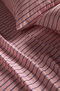 a bed with pink and blue striped sheets