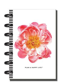 a spiral notebook with the words plan a happy life written on it and a pink flower