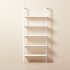 an empty white shelf against a beige wall