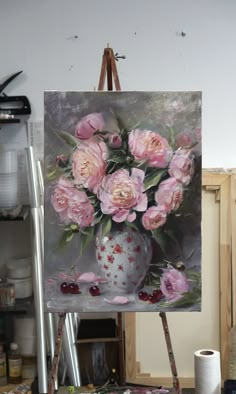 an easel holding a painting with pink flowers in it