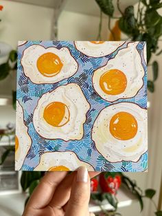 a hand holding up a piece of paper with eggs on it