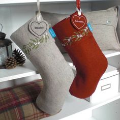 two christmas stockings hanging from hooks on a shelf