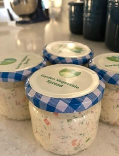 four jars filled with food sitting on top of a counter