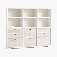 an empty white bookcase with drawers on it