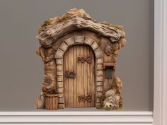 a statue of a wooden door in the shape of a cave with a teddy bear sitting next to it