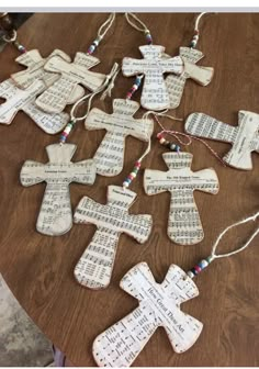 several wooden crosses with sheet music on them sitting on top of a table next to string lights