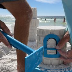 two people building a sand castle at the beach