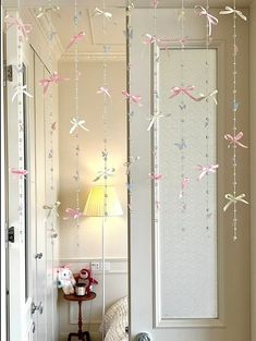 some pink and silver streamers hanging from the ceiling in a room with white walls