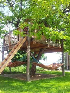 a tree house with a hammock in the yard