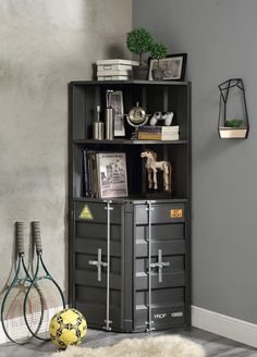 a bookcase with two tennis rackets on top of it next to a wall