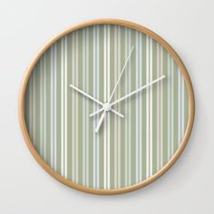 a clock that is on the wall with green and white striped paper covering it's face