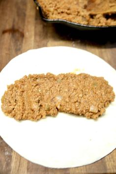 an oatmeal cookie sitting on top of a white plate next to a baking pan