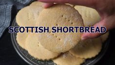 a person is holding a shortbread on a plate with the words scottish shortbread