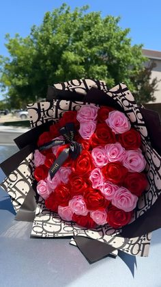 a bouquet of roses sitting on the hood of a car