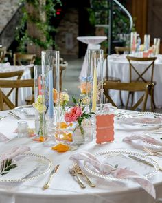 the table is set with flowers and place settings