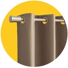 three brown curtains hanging on the side of a yellow wall with an orange circle in the background