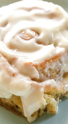 a close up of a plate of food with frosting on it and cinnamon rolls