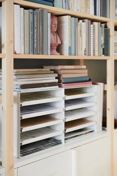 a bookshelf filled with lots of books next to a white cabinet full of books