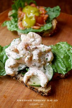 two pieces of bread topped with cucumber and dressing on top of lettuce