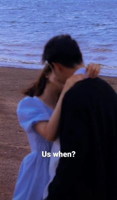 a man and woman standing on top of a beach next to the ocean with text that reads us when?