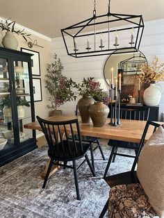 a dining room table with chairs and vases on it