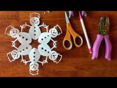 paper snowflakes and scissors on a wooden table