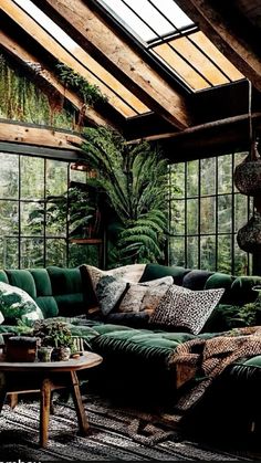 a living room filled with lots of green furniture and plants on the wall next to large windows