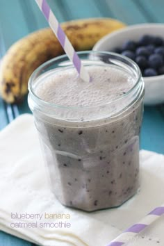 a smoothie with blueberries and bananas in the background