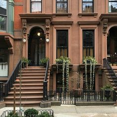 an apartment building with stairs leading up to the front door and second story windows on each side