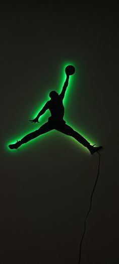 a person jumping in the air with a neon green light on their back and feet