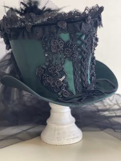 This is elegant Victorian gothic Hand made Bottle green satin Top hat with black back beautifully hand crafted feathers and flowers black net bustle train. Top Hat with Black laces and 3D silk flowers and black pearls and jewels and sequences hand stitched.  Please refer to the photos. This is stunning Victorian Steampunk Handmade top hat made with lots of love. It is very well made, this hat is made of a satin type of fabric and the inside of the hat is has a Black satin  lining. The front of the hat has a corseted details and a black ribbon around the base of the hat. size available - 56 57cm Please note this is full head hat and not mini hat) Height of the hat is 18cm. Please note any markings / traces of glue are characteristics of the fabric and not a defect  Please note:- Even though Steampunk Character Design, Ceil Phantomhive, Green Satin Top, Steampunk Fashion Women, Emerald Green Top, Waistcoat Outfit, Steampunk Character, Clothes To Draw, Walking The Plank