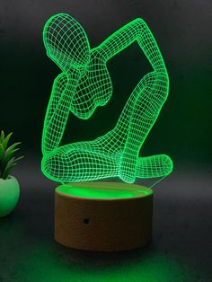 a green light that is sitting on top of a wooden base with a figure in the middle