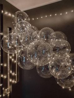 a bunch of clear balls hanging from the ceiling in a room with lights on it