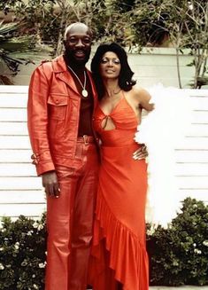 a man and woman dressed in orange posing for a photo