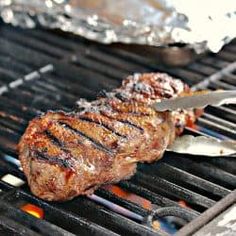 steak on the grill being grilled with tongs