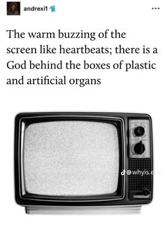 an old tv sitting on top of a wooden table next to a white sign that says, the warn buzzing of the screen like heartbeats there is a god behind the boxes of plastic and artificial