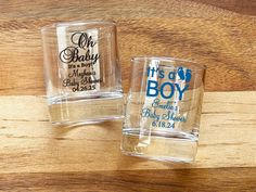 two personalized shot glasses sitting on top of a wooden table next to each other