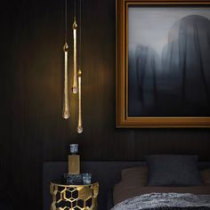 a bedroom with black walls, gold accents and a painting on the wall above it