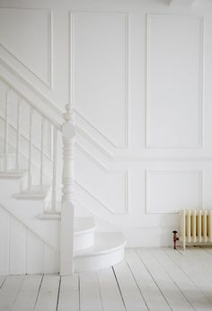 an image of a white room with stairs and paint swatches on the bottom right corner